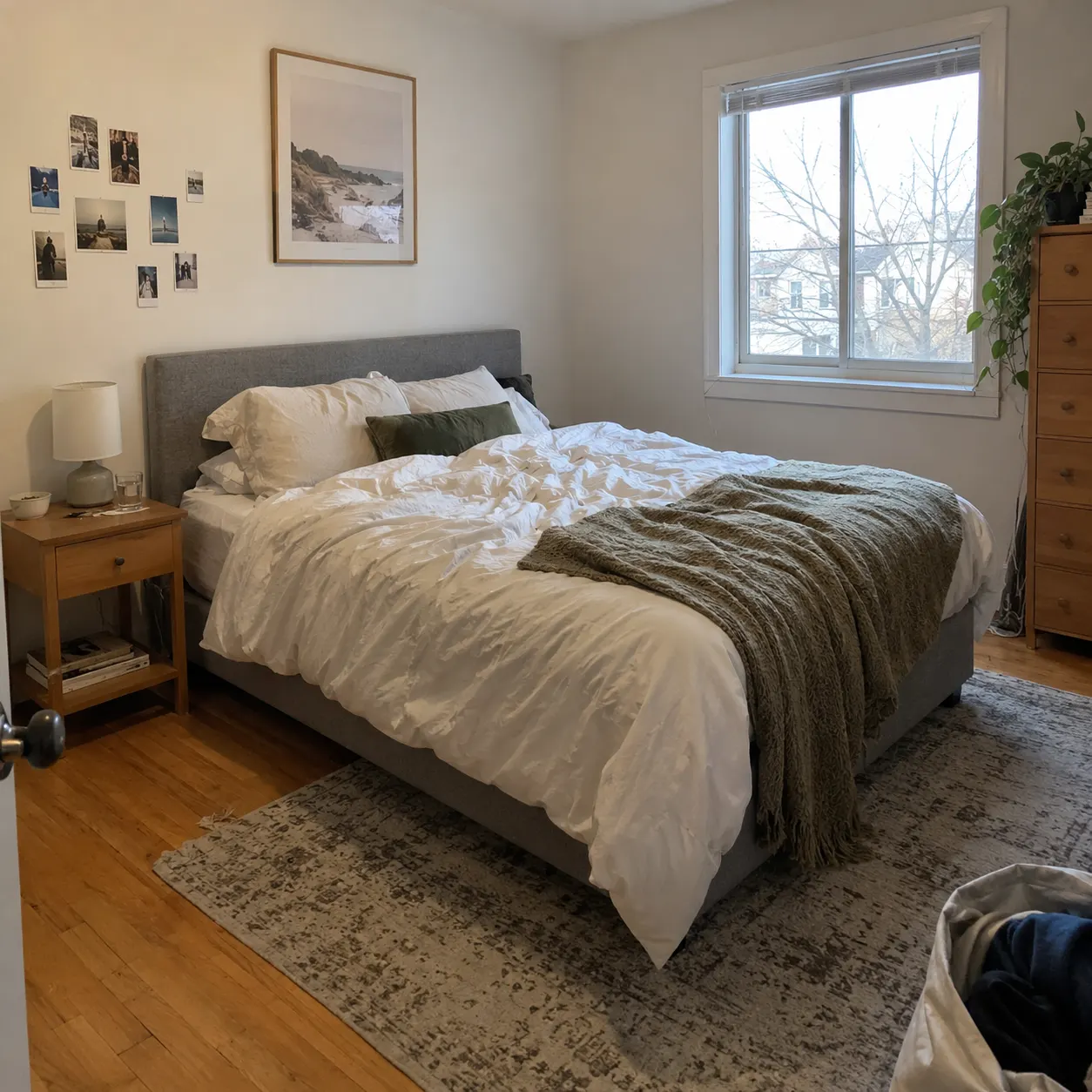 A normal phone photo of a real, lived-in bedroom before redesign: slightly uneven bedding, ordinary furniture, readable walls and floor, and natural indoor light.